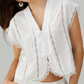 White lace-trimmed top worn by a person